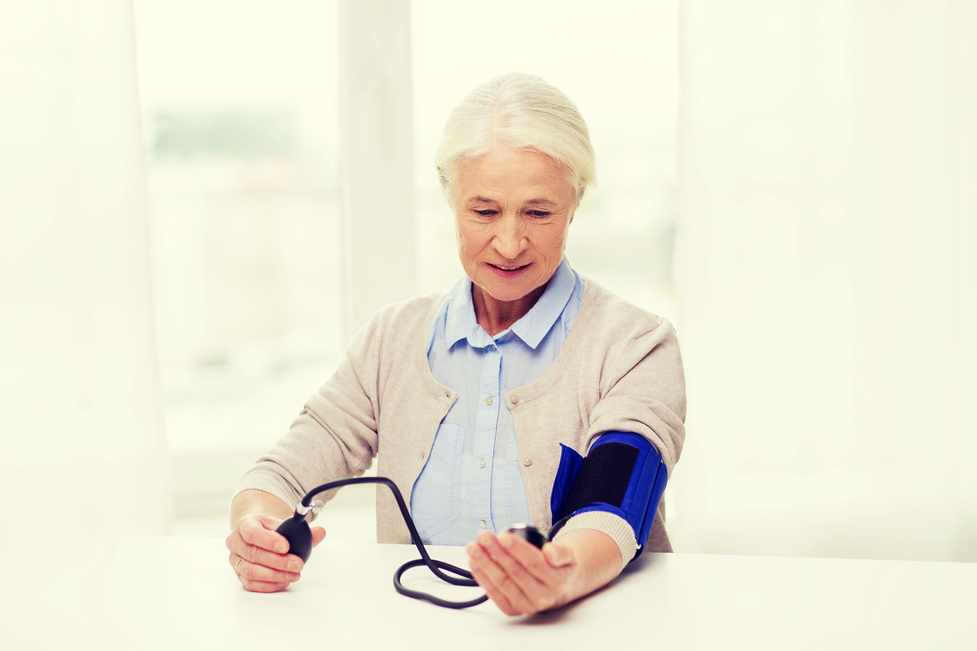 Elderly woman who is measuring her blood pressure.
