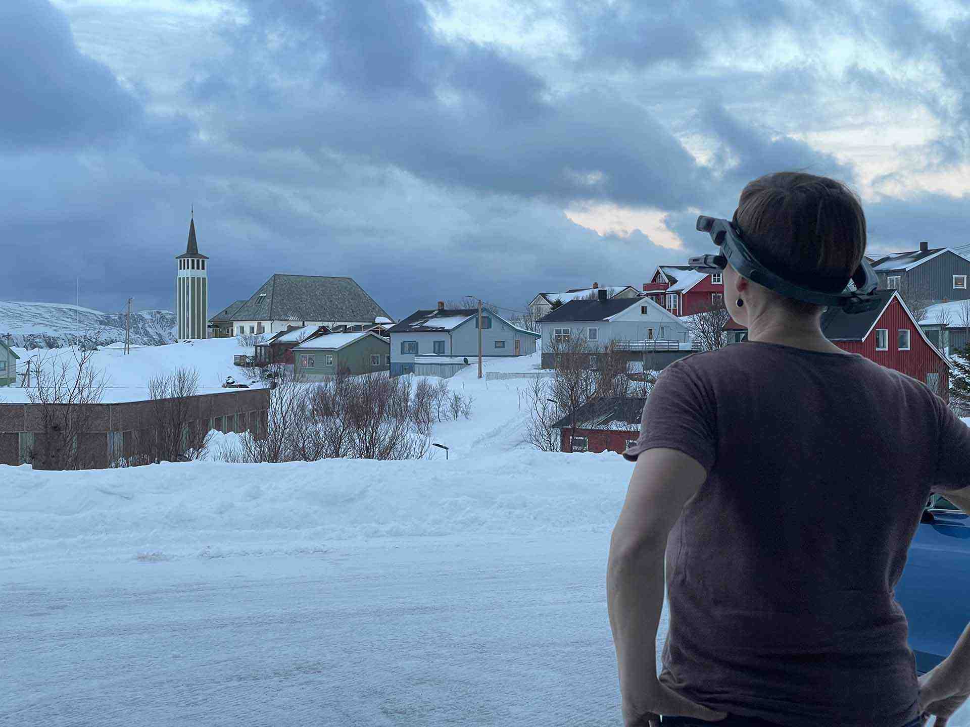 Dame med videobriller ser ut over landsbyen i Norge.